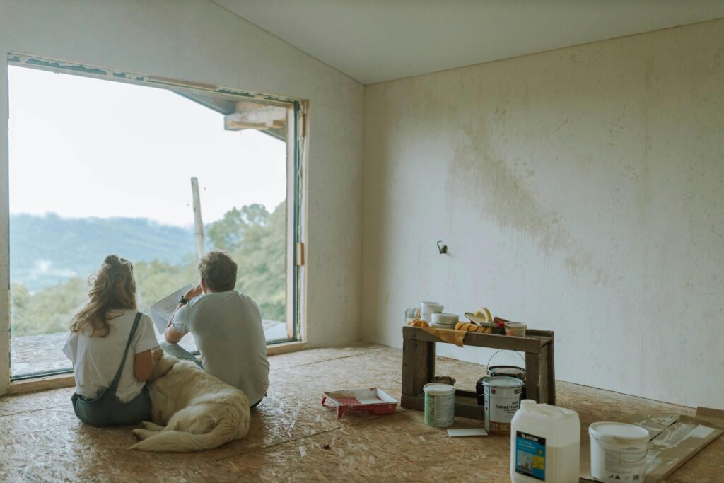 pexels-photo-5481511-5481511 A couple with their dog resting in a partially renovated room, planning the renovation.